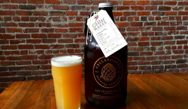 Cellarmaker Brewery Growler next to a glass of beer in front of an exposed brick wall